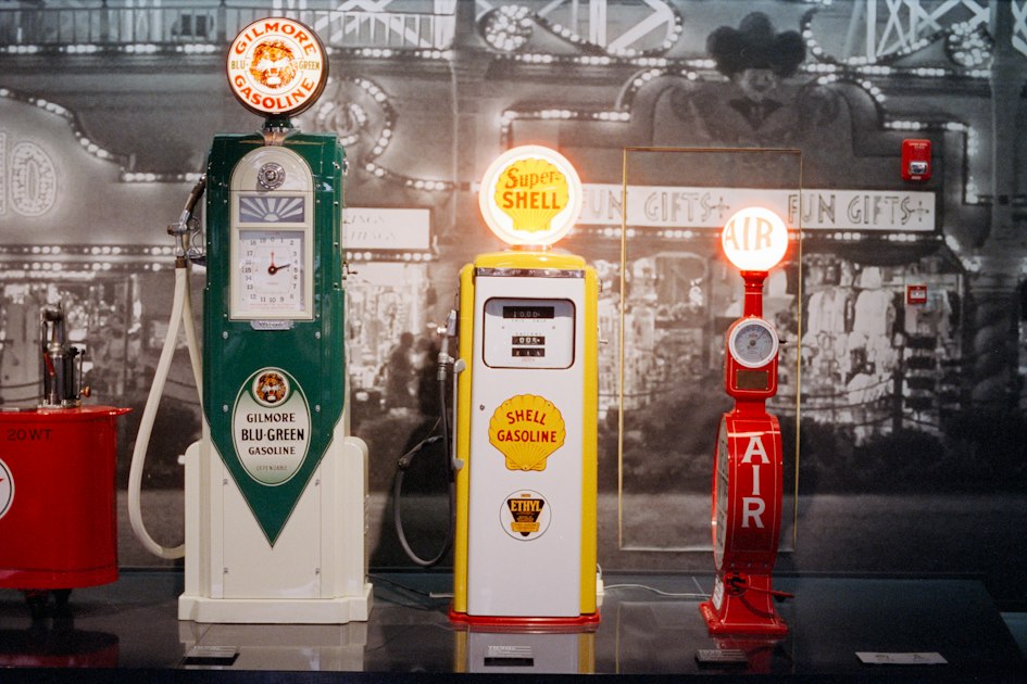 Three vintage gas pumps displayed indoors